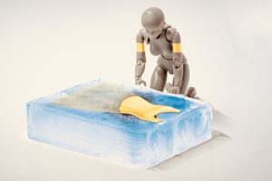 graphic images of a robot looking over an ice block of a yellow dress.