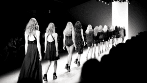 Black and white image of models on a runway.