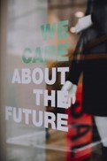 Sign on a window that says "We care about the future" We care is in green.