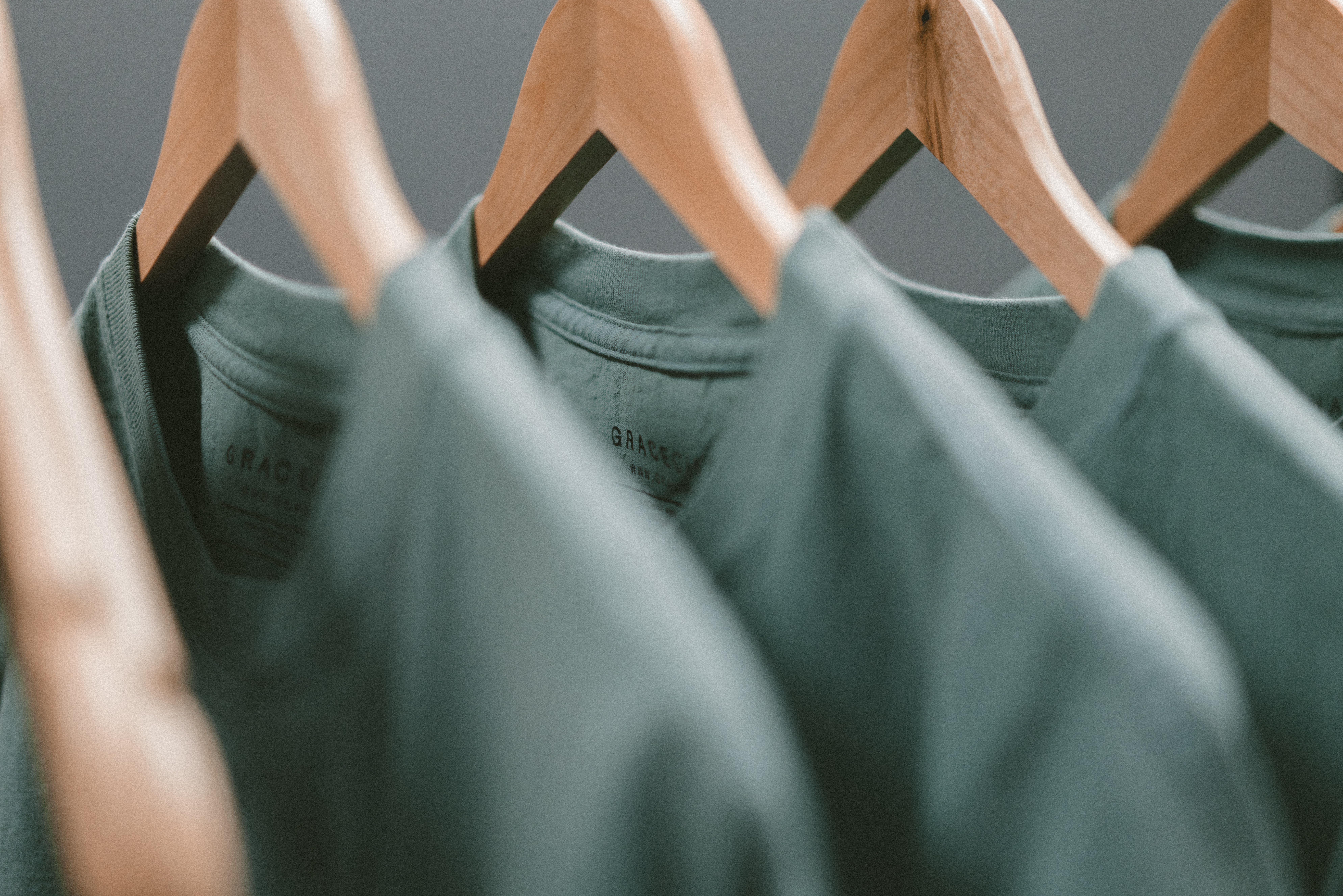 grey shirts on wooden hangers 