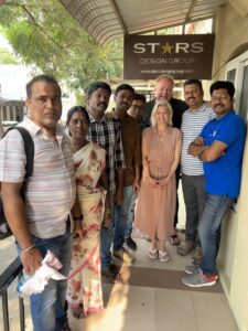 Bret and Emily in front of our Stars Design Group India office with some of our team members