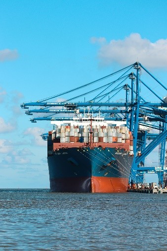 A shipping boat at port with shipping containers