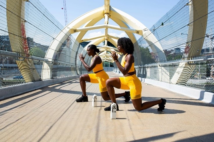 Two women working in yellow workout outfits