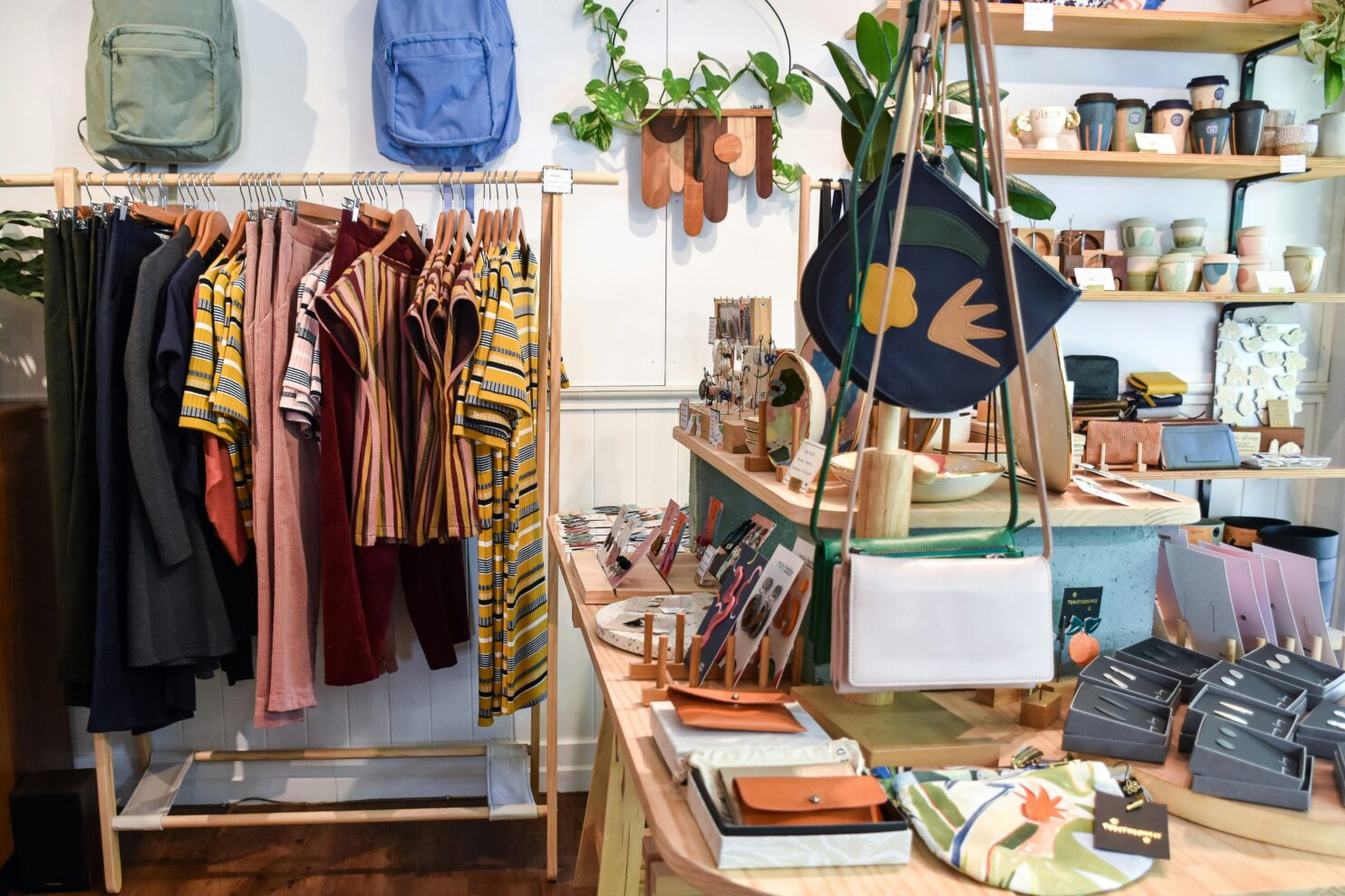 A clothing store with racks and tables with products.